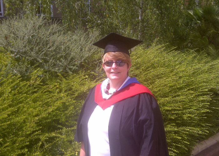 Terry Stuart wearing graduation robes and a mortarboard